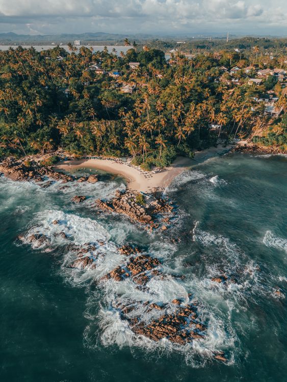 Best Beaches on Sri Lanka's South Coast 2 Aerial view of Mirissa Beach on Sri Lanka's south coast with green coastline and rocky shores