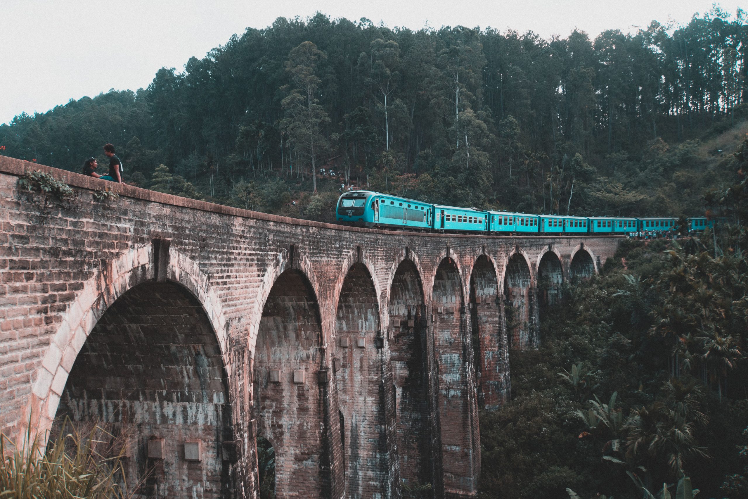Private Driver Tours in Sri Lanka: Top Routes & Ideas 2 Blue train crossing the Nine Arch Bridge near Ella, surrounded by green hills on a scenic Sri Lanka driving route